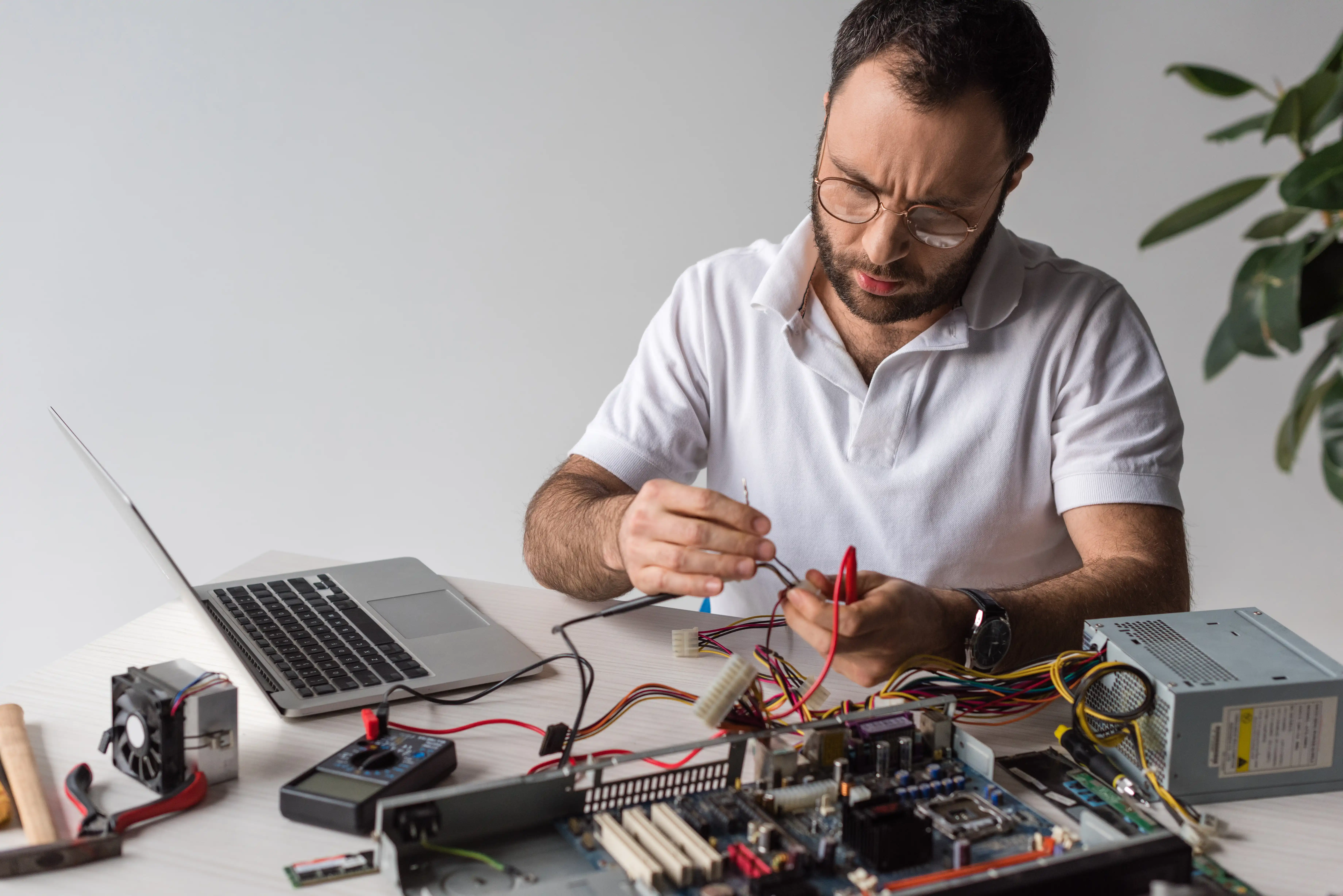 man-using-multimeter-while-fixing-broken-computer-2026-01-06-00-30-44-utc.webp